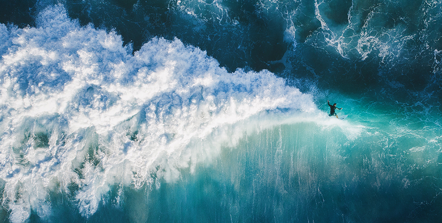 Aerial shot of Surfer riding a wave